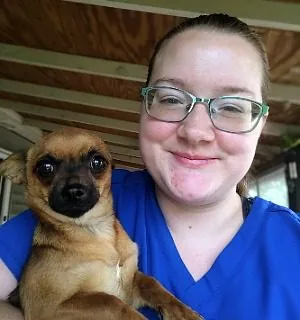 female with glasses holding a chihuahua