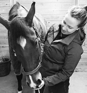 black and white picture of a female feeding a horse